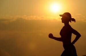 A girl jogging at sunset.